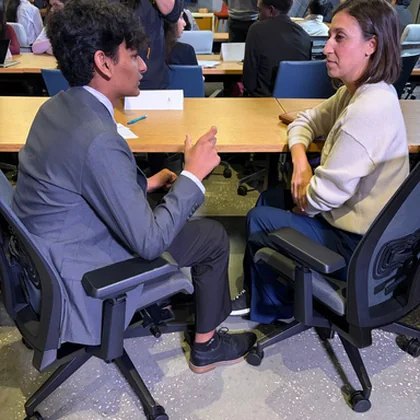 A student and an industry mentor talking across a desk.
