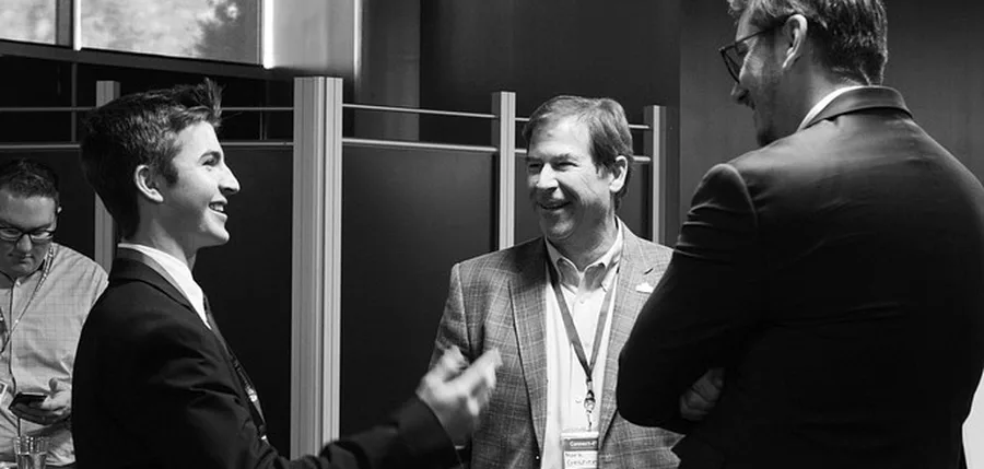 A SharkMakers student talking with two industry mentors at a program event.